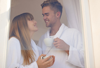 Image showing Couple, morning and drinking coffee by window and relaxing on weekend, romance and hot tea at home. Happy people, bonding and peaceful or cozy, commitment and loyalty to marriage or relationship