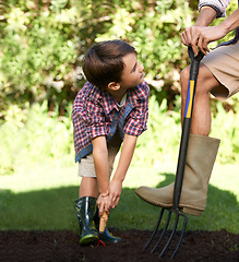 Image showing Child, father and help with gardening in nature using tools for agriculture conservation and ecology education. Soil, compost and a man teaching boy kid to plant with fork for organic earth support
