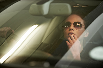 Image showing Woman, driving and mirror to reverse from parking garage for journey or trip with sunglasses. Face, female person and car window to think on roadtrip in vehicle for commute with stylish eyewear