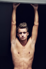 Image showing Shirtless, body and portrait of young man looking serious on a dark background with strength. Topless, muscles and face of a caucasian male person from Norway with confidence and pride for his chest