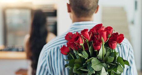 Image showing Happy couple, red roses and kiss for surprise, anniversary or valentines day in kitchen at home. Face of young man and woman smile with flowers for romantic gift, love or care in celebration at house