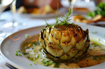 Image showing White Plate With Artichoke Covered in Sauce, A Delectable Dish