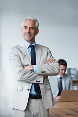 Image showing Senior businessman, professional and confidence in leadership, agency and pride for mentoring in office. Male person, arms crossed and smile for support in management, advisor and laptop for planning