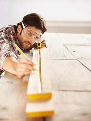 Image showing Man, wood and carpenter with idea, planning and building for home improvement, remodeling and renovation. Handyman, craftsman and contractor with maintenance, wood and skill for measurement or repair