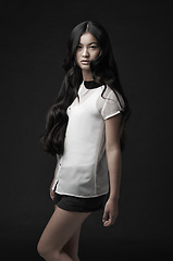 Image showing Woman, portrait and fashion with confidence in studio or dark aesthetic or clothing style, black background or mockup space. Asian person, model and face or serious or Japanese beauty, cool or outfit