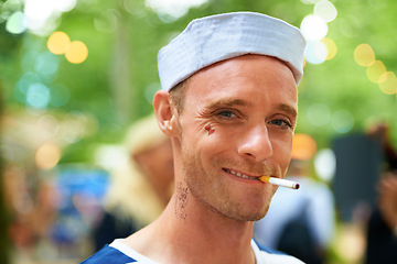 Image showing Portrait, smile and man with a cigarette, music festival and sailor outfit with fun and costume. Face, person and guy with tobacco, outdoor or nicotine with concert or happy with culture or bad habit