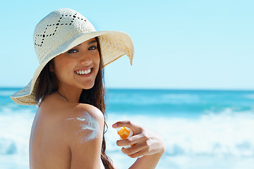 Image showing Woman, portrait and beach with sunscreen on shoulder for skin, health and happy by waves for vacation. Girl, person and smile with hat, serum and sunblock for uv light, sunburn and safety in Naples