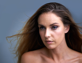 Image showing Woman, face and beauty with makeup, cosmetics or skincare on a blue studio background. Attractive female person, brunette or model with eye liner, shadow or skin tone for facial treatment on mockup