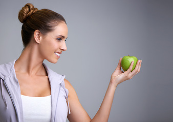Image showing Happy, health and woman in studio with apple, offer or mockup for fiber or gut health on grey background. Nutrition, space and model with fruit for weight loss help, nutrition or raw superfoods diet