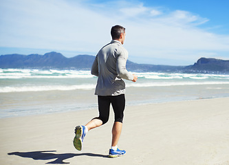 Image showing Back, space or man at beach running for exercise, training or outdoor workout at sea for fitness. Sports person, mature runner or healthy athlete on sand for cardio endurance, wellness or mockup