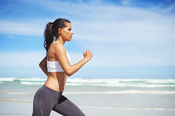Image showing Fitness, Indian or woman on beach running for exercise, training or outdoor workout at sea. Sports person, runner or healthy athlete in nature for cardio endurance, wellness or challenge on sand
