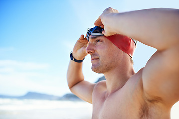 Image showing Beach, goggles and man with vacation, cap and swimmer with holiday and summer break with getaway trip. Person, athlete and player with protection and seaside with sunshine and fitness with wellness