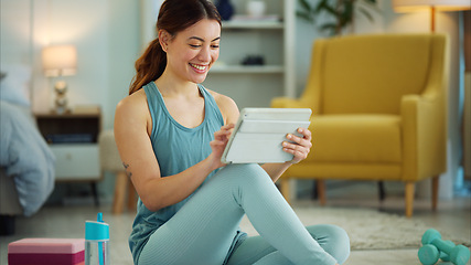 Image showing Fitness, internet and woman streaming on a tablet for training, yoga and exercise on the floor of her house. Happy, young and wellness girl with technology for a workout, cardio or video on pilates