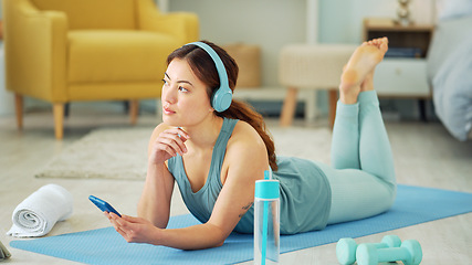 Image showing Smartphone, yoga and headphones of woman typing on chat app for fitness communication, social media update or blog writing wellness. Pilates girl with exercise gear and technology in home living room