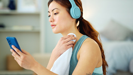 Image showing Woman, phone and yoga with rest, towel and music while sitting, floor and relax in living room. Girl, headphone and smartphone for streaming, video or reading while taking break, training or fitness