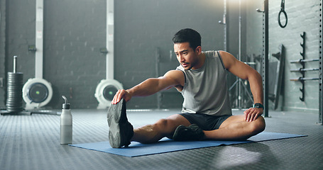 Image showing Man, break and stretching on gym floor in fitness, workout or training for strong muscles, heart health or cardio wellness. Japanese personal trainer, sports person or coach in body warmup exercise