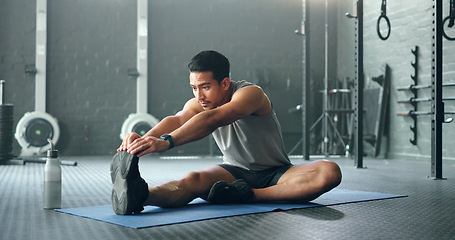 Image showing Man, break and stretching on gym floor in fitness, workout or training for strong muscles, heart health or cardio wellness. Japanese personal trainer, sports person or coach in body warmup exercise