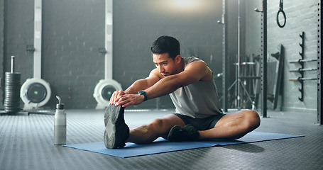 Image showing Man, break and stretching on gym floor in fitness, workout or training for strong muscles, heart health or cardio wellness. Japanese personal trainer, sports person or coach in body warmup exercise