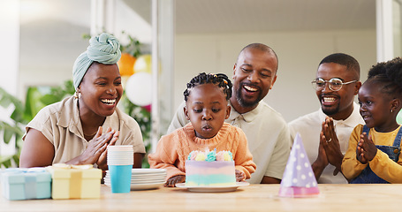 Image showing Birthday, kids party and applause with a black family in celebration of a girl child in their home. Parents, grandparents and children clapping while blowing candles on a cake at a milestone event