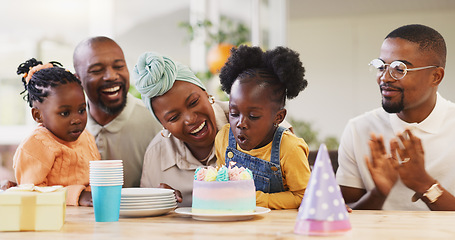 Image showing Birthday, children party and applause with a family in celebration of a girl child in their home. African parents, grandparents and kids clapping while blowing candles on a cake at a milestone event