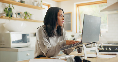 Image showing Laptop, documents and remote work with a woman entrepreneur in the kitchen of her home for small business. Computer, report and a young female freelance employee working on a startup from her house