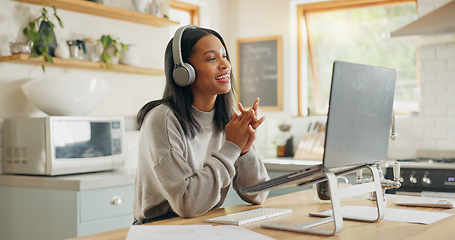 Image showing Laptop, headphones and video call with a woman entrepreneur in the kitchen of her home for small business. Computer, virtual meeting and a young freelance employee remote working from her house