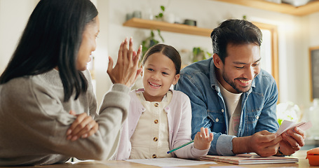 Image showing High five, girl with parents and support with learning in house with card, game or mom and dad helping with homework together in home. Child, family and development of education with math games