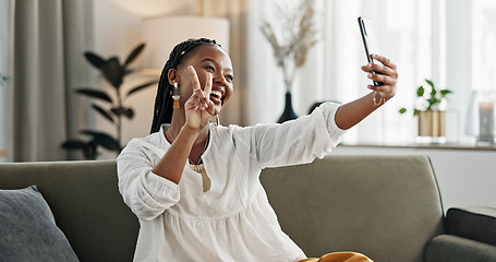 Image showing Smile, selfie and black woman with peace sign, funny face and relax on sofa in living room. V hand, picture and happy African person or influencer at home on couch on social media with tongue out