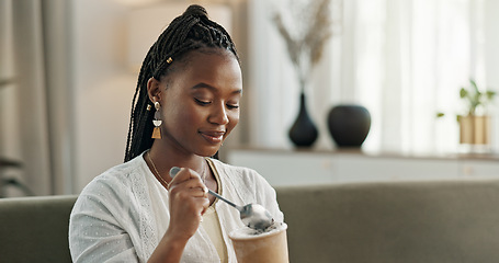 Image showing Black woman on sofa, eating ice cream and relax in living room with smile, summer pleasure and enjoy. Happiness, fun or thinking, girl on couch with taste of frozen chocolate getalo dessert in home.