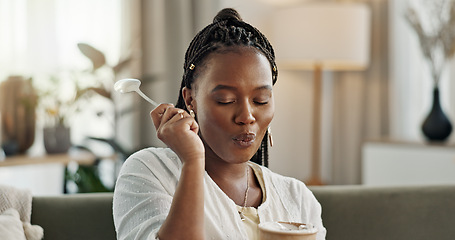 Image showing Black woman on sofa, eating ice cream and relax in living room with smile, summer pleasure and enjoy. Happiness, fun or thinking, girl on couch with taste of frozen chocolate getalo dessert in home.