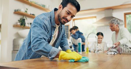 Image showing Family, cleaning and man in a kitchen with cloth for table, hygiene or clean living space after dinner. House, disinfection and guy parent with household chore for safety from bacteria, dirt or germs