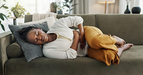 Image showing Home, pain and black woman on a couch, cramps and stomach with sickness, suffering and disease in the living room. African person, apartment and girl with abdominal problem, tummy ache and period