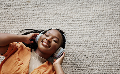 Image showing Home, music and black woman on a couch, headphones and streaming audio in a living room. African person on a sofa, apartment or girl with headset, listening to sound and relax with happiness or song