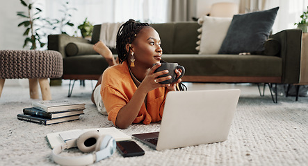 Image showing Laptop, coffee and woman on the floor in living room of modern apartment reading information. Technology, relax and young African female student study and drink latte on computer in lounge at home.