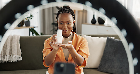 Image showing Smile, live streaming and black woman with serum for beauty and open skincare box. Happy, influencer and cosmetics, review product and content creation on social media, ring light and phone at home