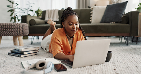 Image showing Laptop, education and a student black woman on the floor of a living room to study for a test or exam. Computer, smile and a happy young person learning with an online course for upskill development