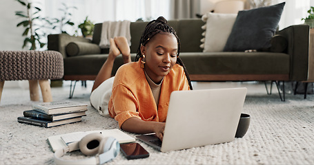 Image showing Laptop, education and a student black woman on the floor of a living room to study for a test or exam. Computer, smile and a happy young person learning with an online course for upskill development