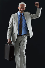 Image showing Excited, portrait and senior businessman with suitcase in studio, celebration or winner fist on black background. Travel, success and elderly entrepreneur face with yes hands for opportunity or deal