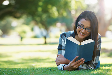 Image showing Happy woman, student and reading book in nature for literature, studying or story on green grass. Female person, smart or young adult with smile or glasses for chapter, learning or outdoor education