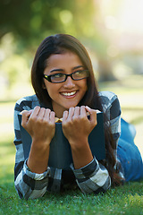 Image showing Happy woman, student and relax with book for reading, literature or studying on green grass. Young nerd, geek or female person with smile and glasses for chapter, learning or outdoor story in nature