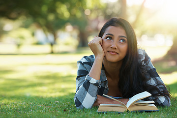 Image showing Happy woman, student and thinking with book for reading, literature or studying on green grass. Young or thoughtful female person with smile in wonder for chapter, learning or outdoor story in nature