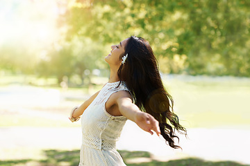 Image showing Nature, freedom and woman dancing in outdoors, smiling and relaxed on vacation in garden for peace. Happy female person, fun and enjoyment on holiday in forest, adventure and travel to countryside