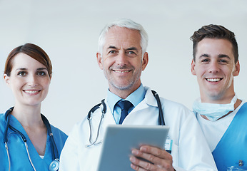 Image showing Tablet, smile and portrait of doctor with nurses in hospital for medical diagnosis or treatment discussion. Team, digital technology and senior surgeon with healthcare workers for surgery in clinic.