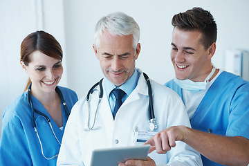 Image showing Tablet, research and doctor with nurses in hospital for medical diagnosis or treatment discussion. Team, digital technology and senior surgeon talking to healthcare workers for surgery in clinic.