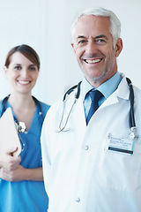 Image showing Happy, portrait and senior doctor with nurse in hospital with clipboard for medical research in collaboration. Smile, checklist and mature male surgeon with healthcare worker in clinic for teamwork.