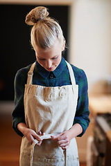 Image showing Chef, woman and tie apron in kitchen, restaurant or catering service at hotel for gastronomy. Uniform, cooking and person with knot on clothes, culinary or preparation of professional waitress at job