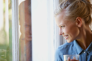 Image showing Thinking, smile and woman with coffee in a house for peaceful, reflection or moment at home. Remember, face and female person with happy memory, tea or enjoying me time or weekend at apartment window