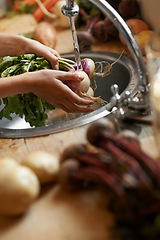 Image showing Washing, vegetables and hands in kitchen for healthy food, hygiene and cooking or preparation by sink. Person with water, liquid and onion for meal, dinner or organic, vegan and vegetarian lunch