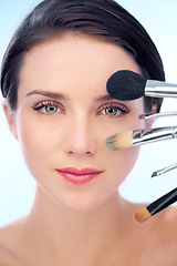 Image showing Woman, portrait and makeup brushes in studio with skincare, cosmetic tools or product application for beauty. Model, face and confidence with skin wellness, cosmetology or grooming on blue background