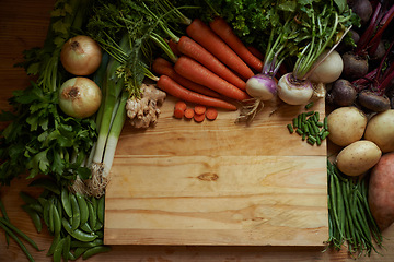 Image showing Vegetables, kitchen and empty cutting board for healthy food, cooking and preperation on table above. Culinary, organic and green groceries for vegan or vegetarian recipe and ingredients background